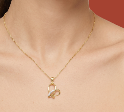 Heart-knot lab diamond pendant on a person’s neckline with gold-tone chain