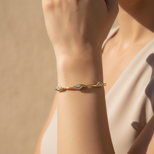 Yellow gold vermeil twist bangle with small lab diamond accents, on wrist